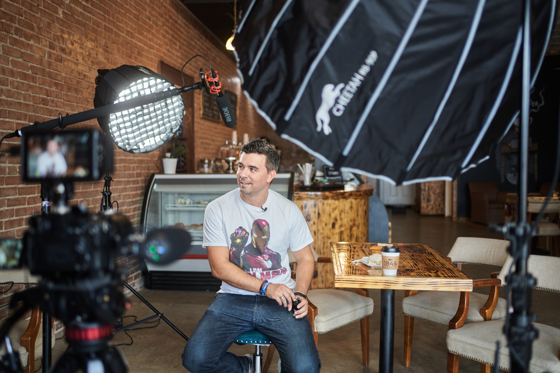 A Cedar Hill business owner being interviewed on camera in a local coffee shop