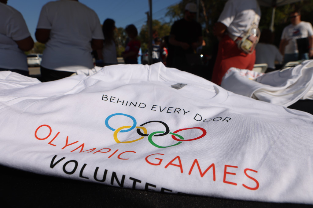 Behind Every Door Olympic Games volunteer shirts at a community event